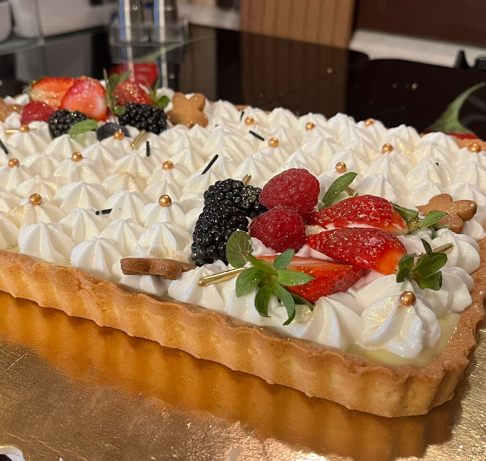 Crostata moderna con crema di budino alla vaniglia, ciuffetti di panna e frutti di bosco